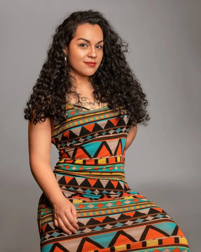Melissa Cabrera con cabello largo rizado oscuro usando un vestido colorido con patrón geométrico